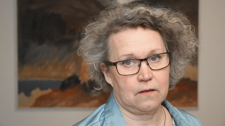 En kvinna med glasögon och en blå skjorta.