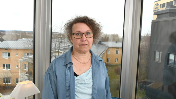 En kvinna som st&aring;r framf&ouml;r ett f&ouml;nster.
