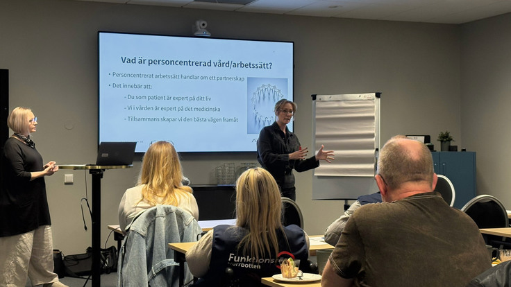 En grupp m&auml;nniskor som st&aring;r framf&ouml;r en projektorduk.