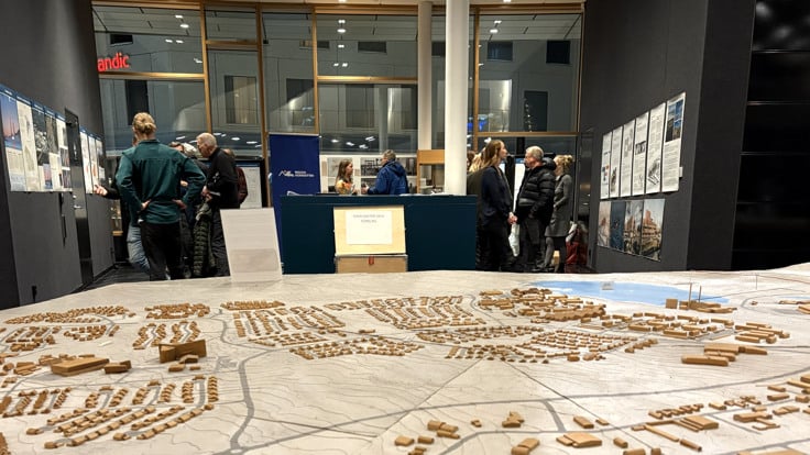 En grupp m&auml;nniskor som tittar p&aring; en stadsmodell.