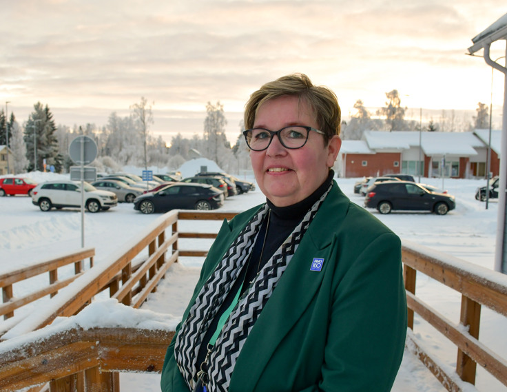 Porträttbild av leende kvinna med en vintrig bakgrund