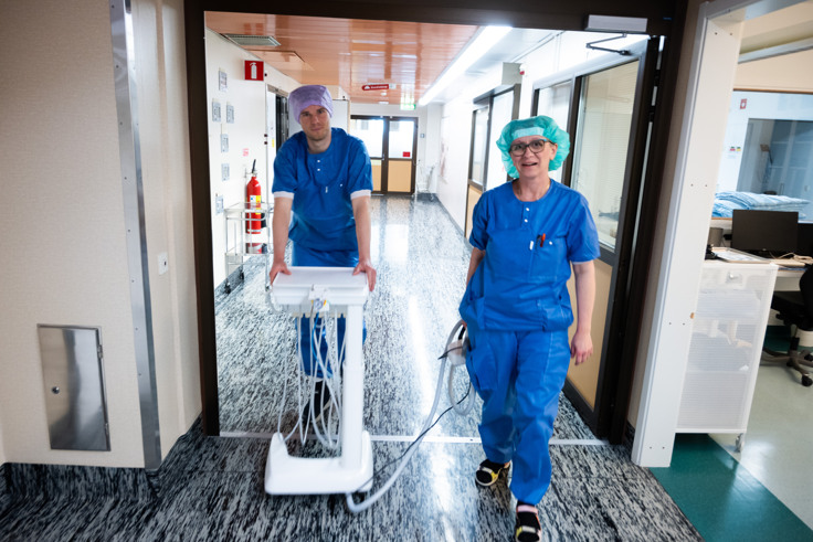 Tv&aring; personer g&aring;r l&auml;ngs en korridor.