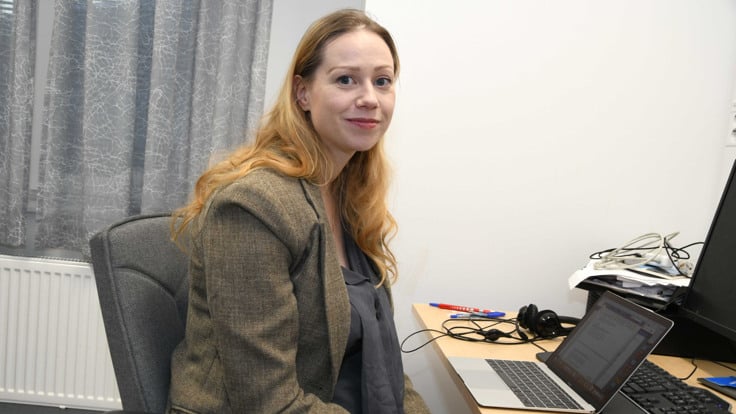 En kvinna som sitter i en stol framf&ouml;r en dator.