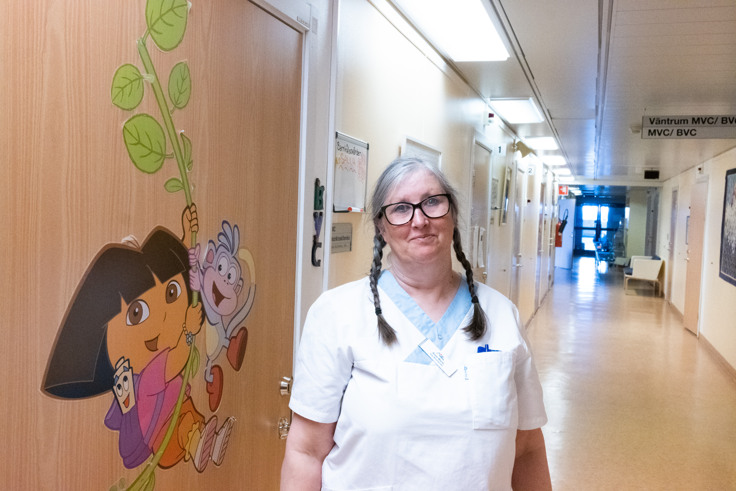 En kvinna som st&aring;r i en sjukhuskorridor.