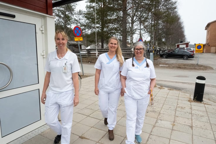 En grupp sjuksk&ouml;terskor som g&aring;r l&auml;ngs en trottoar.