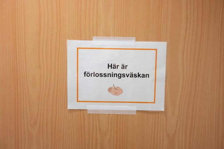 En skylt p&aring; en tr&auml;d&ouml;rr.