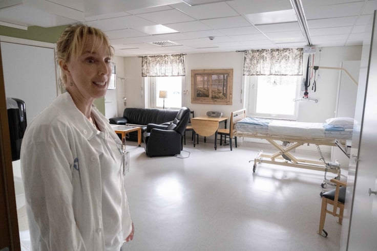 En arbetskl&auml;dd kvinna som st&aring;r i ett rum.