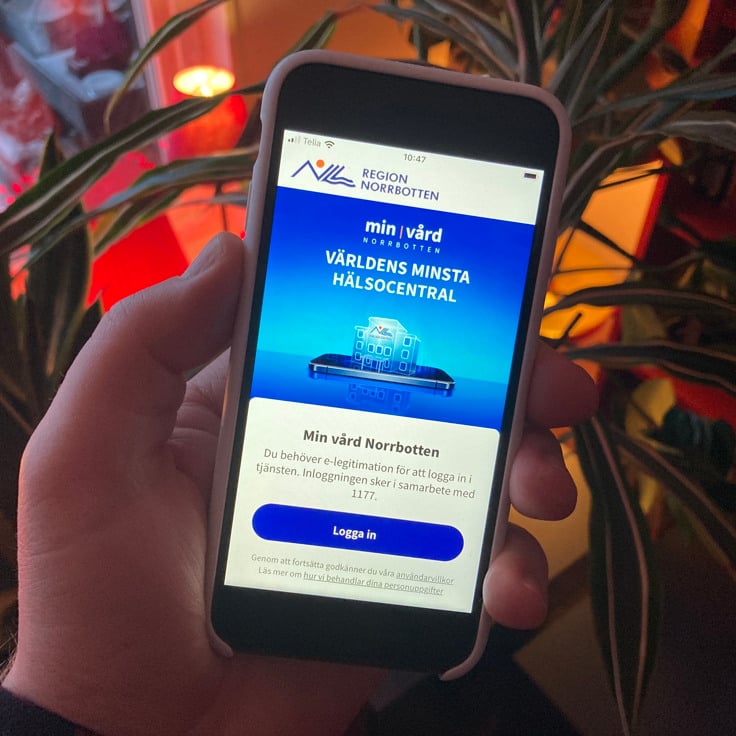 Person som håller i en mobil i ett kök.