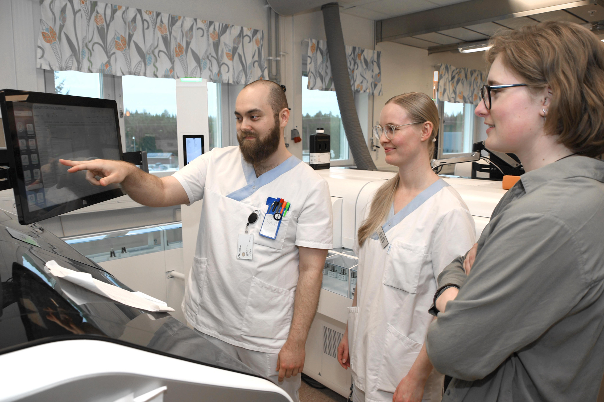 Nyblivna biomedicinska analytikerna Sam Holmberg, Elida Björk och Julia Grönlund vid laboratoriemedicins automatbana.