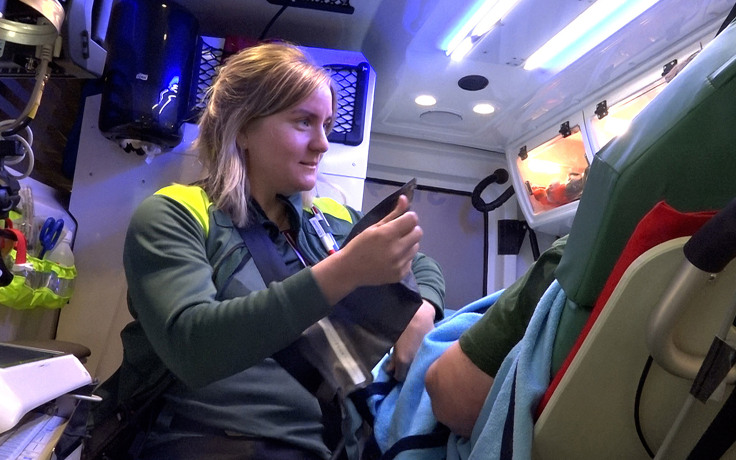 Ambulanssjuksköterska vårdar patient i ambulans.