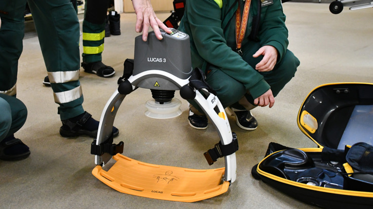 En kvinna som kn&auml;b&ouml;jer bredvid en v&auml;ska fylld med utrustning.