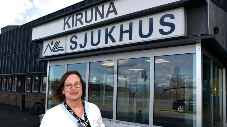 En kvinna som st&aring;r framf&ouml;r en byggnad.