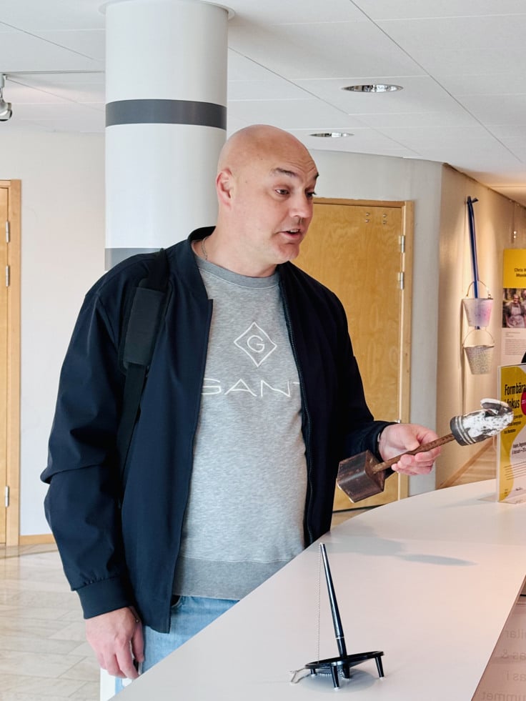 Niklas Larsson st&aring;r med en skulptur vid receptionen i Regionhuset