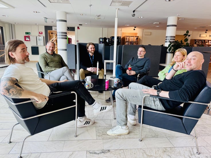 Niklas Larsson sitter med sina kollegor och dricker kaffe.