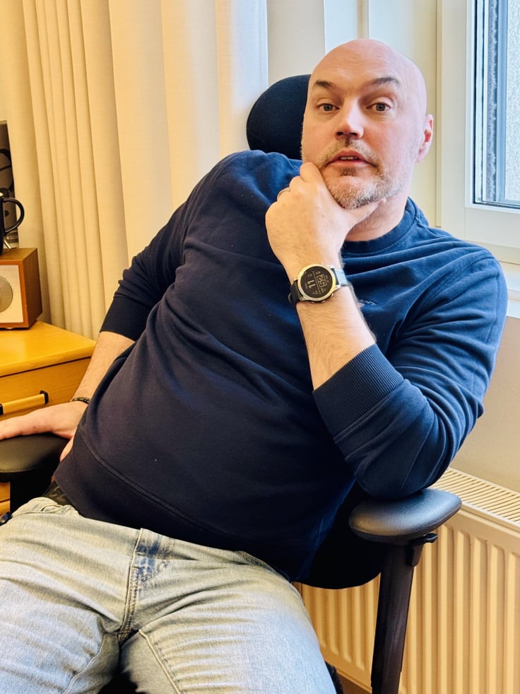 Niklas h&aring;ller hakan i handen. Han sitter p&aring; en kontorsstol.