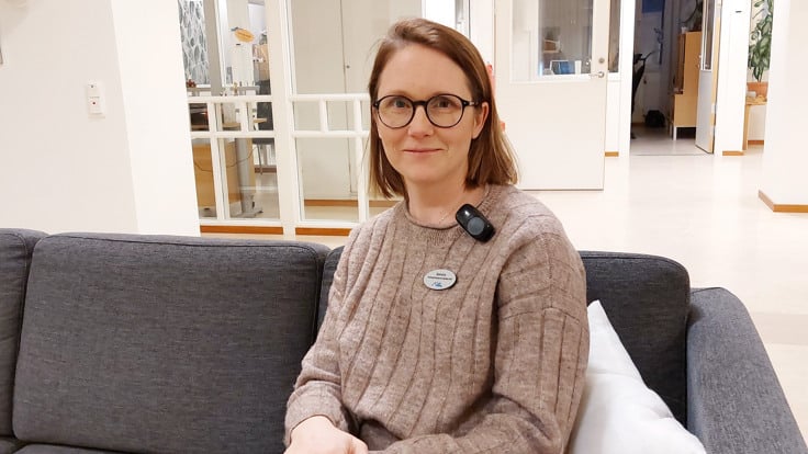 En kvinna som sitter p&aring; en soffa.