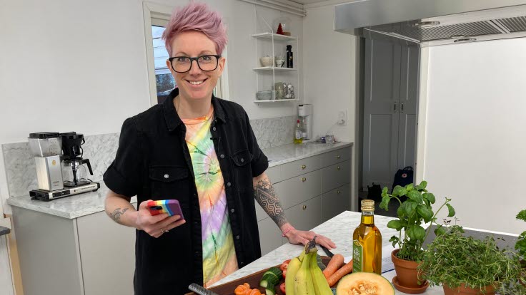 Person som håller i en mobil i ett kök