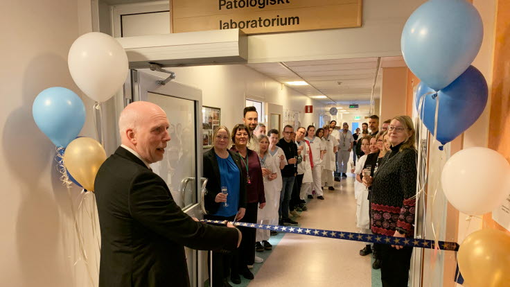 Bandklippning av regionrådet Anders Öberg i korridor tillsammans med personal.