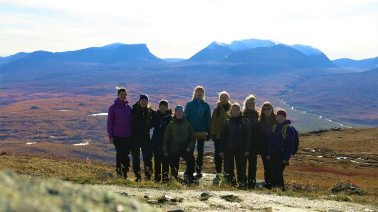 Personalgrupp i Abisko med dalgång och fjäll i bakgrunden.