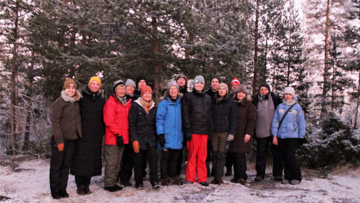 	Stående människor med vinterkläder i en frostig skog.