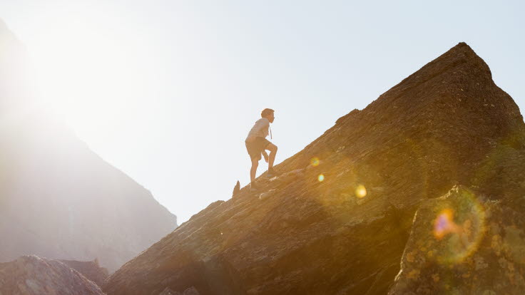 En pojke som klättrar på ett berg