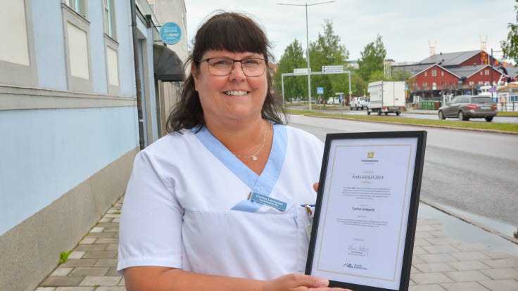Carina Lindqvist tittar in i kameran med diplomet i handen.