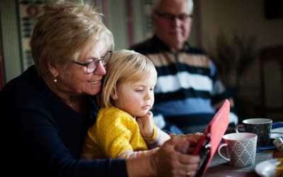 Mormor använder surfplatta med barnbarn