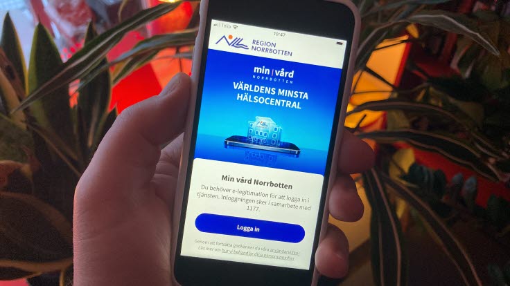 Person som håller i en mobil med appen Min vård Norrbotten.