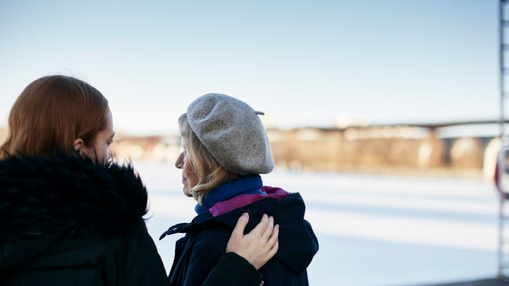 En ung kvinna lägger sin hand på en äldre kvinnas axel