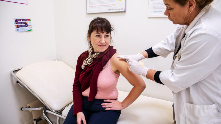 Person som blir vaccinerad mot covid-19 av vårdpersonal