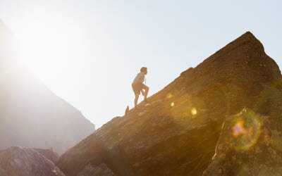 En pojke som klättrar på ett berg