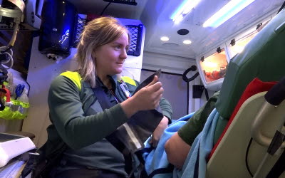 Ambulanssjuksköterska vårdar patient i ambulans.